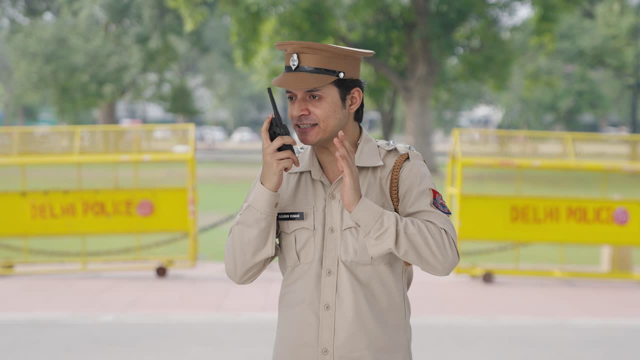 화난 인도 경찰관 이 워키 토키 를 통해 지시 를 주고 있다