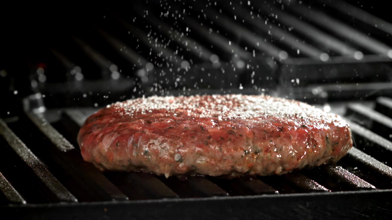 Slow Motion of Salt Sprinkling on a Raw Burger Patty