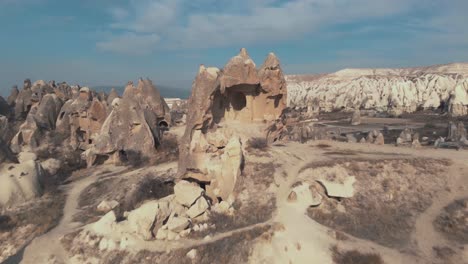 pull-back, 4k aerial drone footage of the remains of a carved home in cappadocia of central turkey