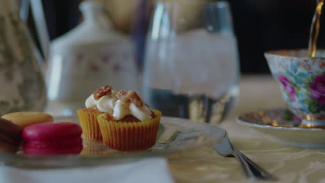 Close-Up-of-Tea-Being-Poured-with-French-Desserts-in-the-Foreground