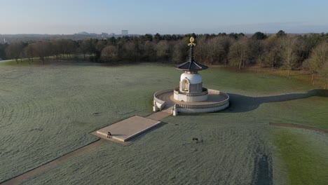 an aerial view of the peace pagoda at willen lake in milton keynes, on a cold winter morning with the sun shining