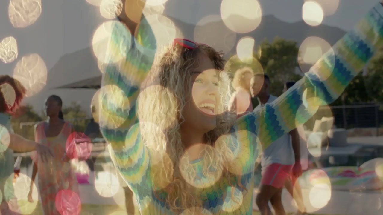 Kvinde løfter armene og danser ved poolen, hvilket får bokeh til at forsvinde og afslører ansigtet til markedsføring.