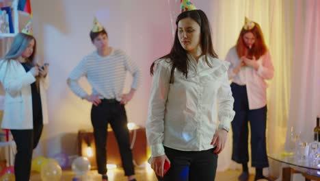 mujer morena aburrida mirando a sus amigos navegando por internet en teléfonos inteligentes y saliendo de la fiesta de cumpleaños. retrato de una encantadora dama caucásica cansada de la celebración. concepto de estilo de vida