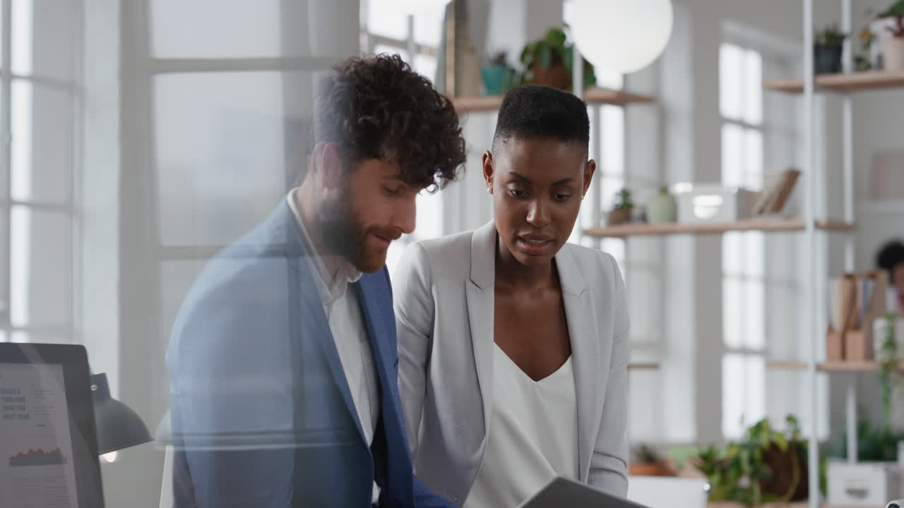 african american business woman team leader brainstorming with colleague using laptop computer showing ideas pointing at screen working together in office