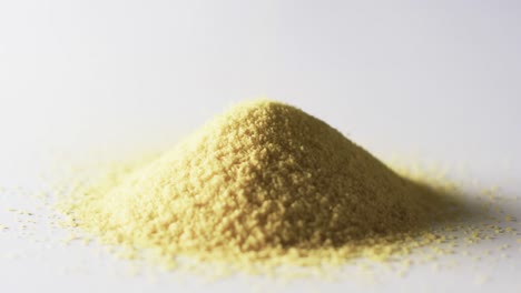 video of close up of heap of yellow sand grains and copy space on white background