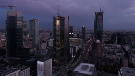 Downtown-skyscrapers-after-sunset.-Tilt-down-revealing-busy-streets-and-large-roundabout.-Warsaw,-Poland