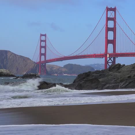 A-view-across-Baker-Beach-in-San-Francisco-to-the-Golden-Gate-Bridge-with-waves-crashing-on-shore