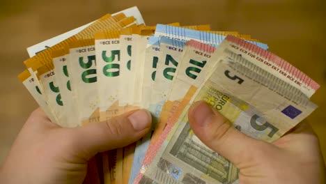 womans hands counting stack of euro cash money