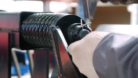 Worker hammering cotter pin into metal part during manual assemble