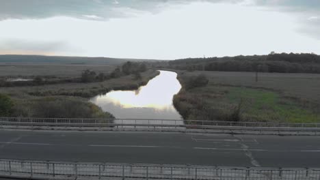 Car-drive-on-bridge-over-river---aerial-shot-1