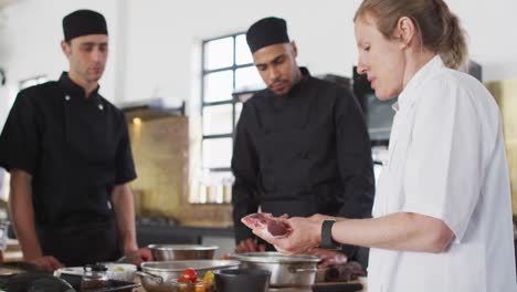 cocinera caucásica que enseña a un grupo diverso