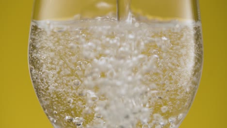 sparkling water with bubbles in a glass, close up