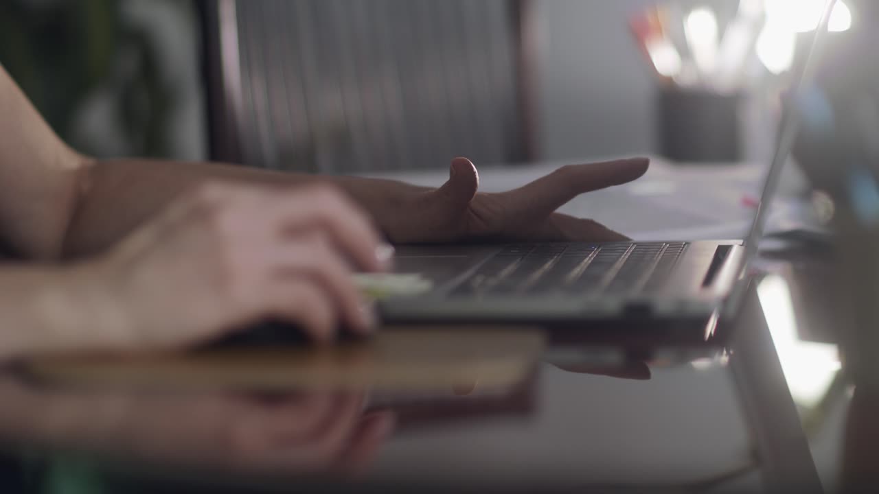 Female hands using mouse and laptop in home