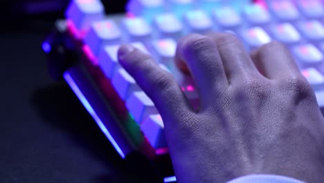 young man hand using the w, a, s, d keys of a mechanical keyboard with led lights