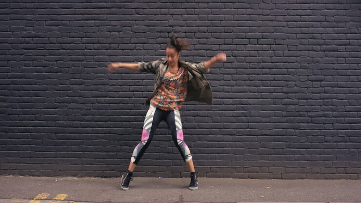 Contemporary funky mixed race woman street dancer dancing freestyle in the city