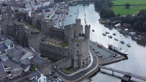 ancient caernarfon castle welsh harbour town aerial view medieval waterfront landmark quick zoom in