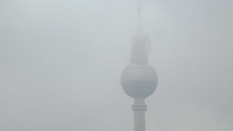 time lapse of berlin television tower hiding behind clouds in misty germany