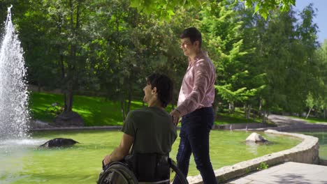 he is having fun-filled moments with his disabled young friend in the city park.