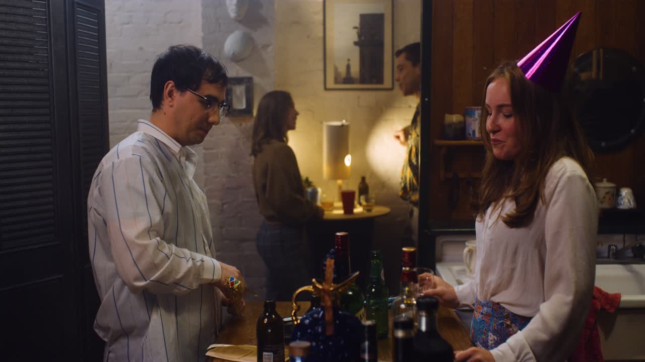 Couple talks in kitchen at a party