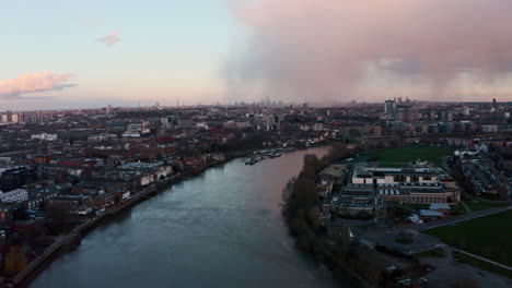 drone shot over river thames towards hammersmith central london sunset