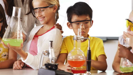 school kids doing a chemical experiment in laboratory