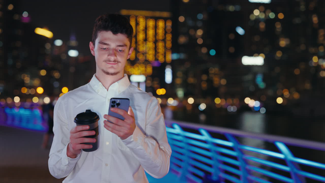 밤에 도시에서 전화를 사용하는 남자