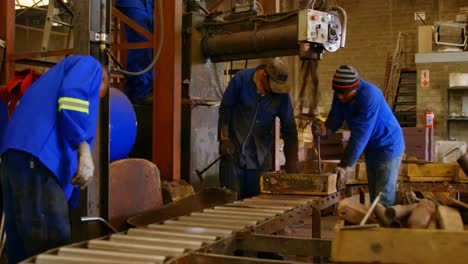 workers putting soil in metal mold in foundry workshop 4k