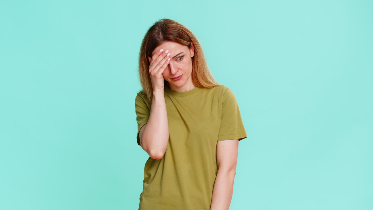 Woman making facepalm and rubbing forehead showing disappointment regret sudden realization moment