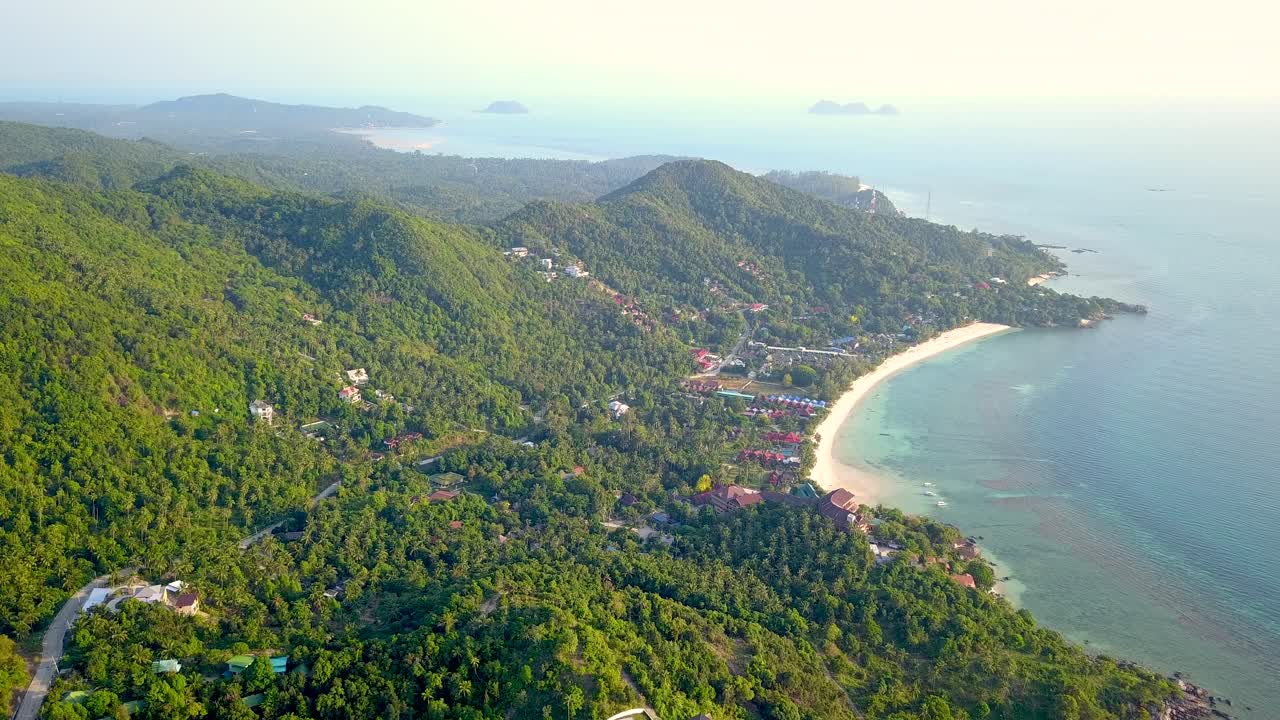 un dron aéreo de 4k empuja la toma de la playa de ensalada en koh phangan en tailandia con barcos de pesca, agua verde azulado, coral y selvas verdes