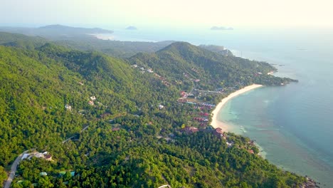 un dron aéreo de 4k empuja la toma de la playa de ensalada en koh phangan en tailandia con barcos de pesca, agua verde azulado, coral y selvas verdes