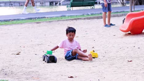 young boy enjoys playing with toys outdoors