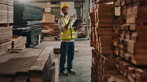 worker checking inventory in lumber warehouse
