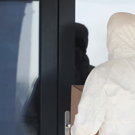 a man in a protective suit brought a box to the door