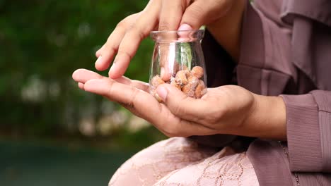 woman holding a small glass jar with sugared nuts