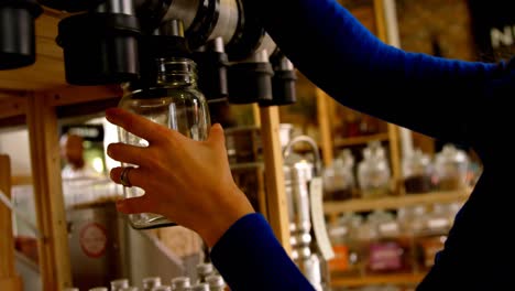 close-up of woman filling grains in to jar from vending machine 4k