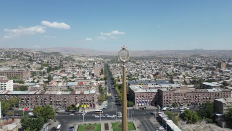 aerial retreats from old soviet armenian crest on spire over yerevan