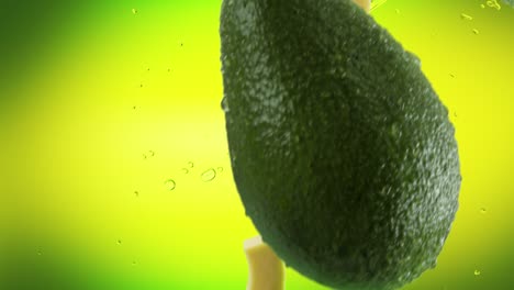 aguacate con rebanadas y salpicaduras cayendo sobre un fondo verde lima