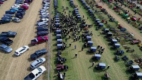 aerial view of an amish mud sale auctioning buggies, farm equipment to quilts on a winter day