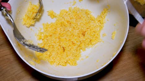 two females are taking coconut cookies dough from white pot to cook in oven