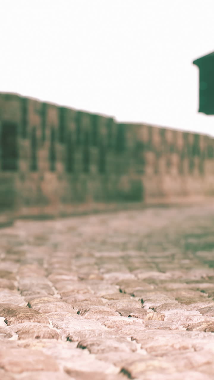 Cobblestone street in front of an old stone wall