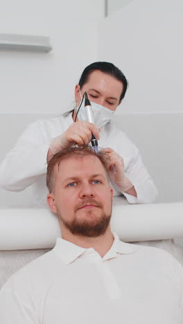 trichologist doing man improve hair growth procedure dermapen microneedling vitamin injections