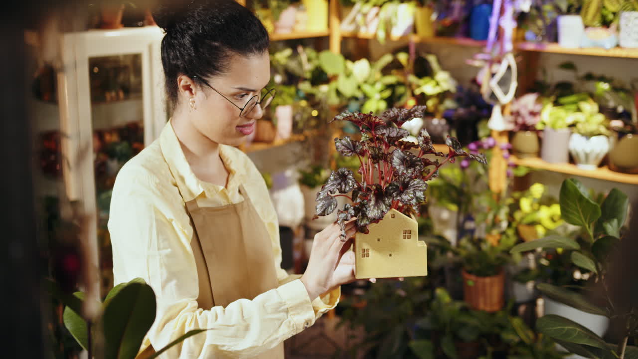 꽃 가게 가 실내 식물 을 조사 하고 있다