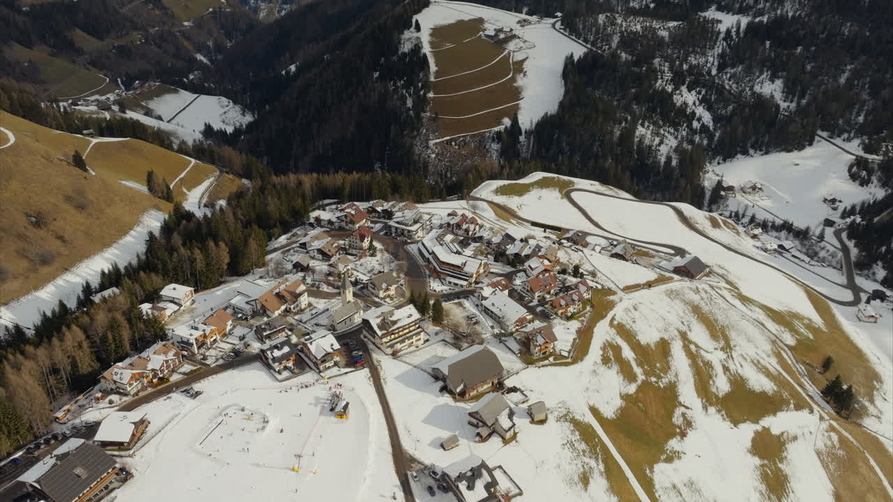 vista aérea de la aldea de la estación de esquí de nieve en la cima de una colina cubierta de nieve ubicada cerca de grande sass de putia