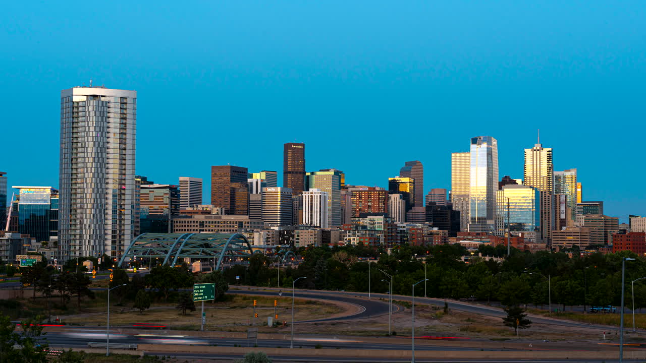 Time-lapse dinámico de día a noche del tráfico y el horizonte iluminado de Denver.