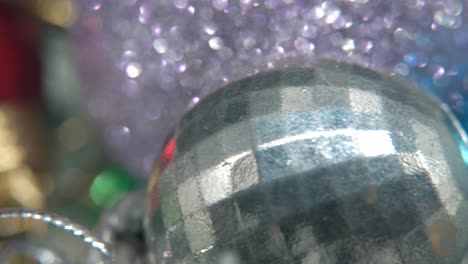 decoración de navidad, coloridos adornos de cristal bolas coloridas en un soporte giratorio 360 año nuevo decorado, luces brillantes, cinematográfico primer plano macro video 4k constante, hermosa profundidad de campo