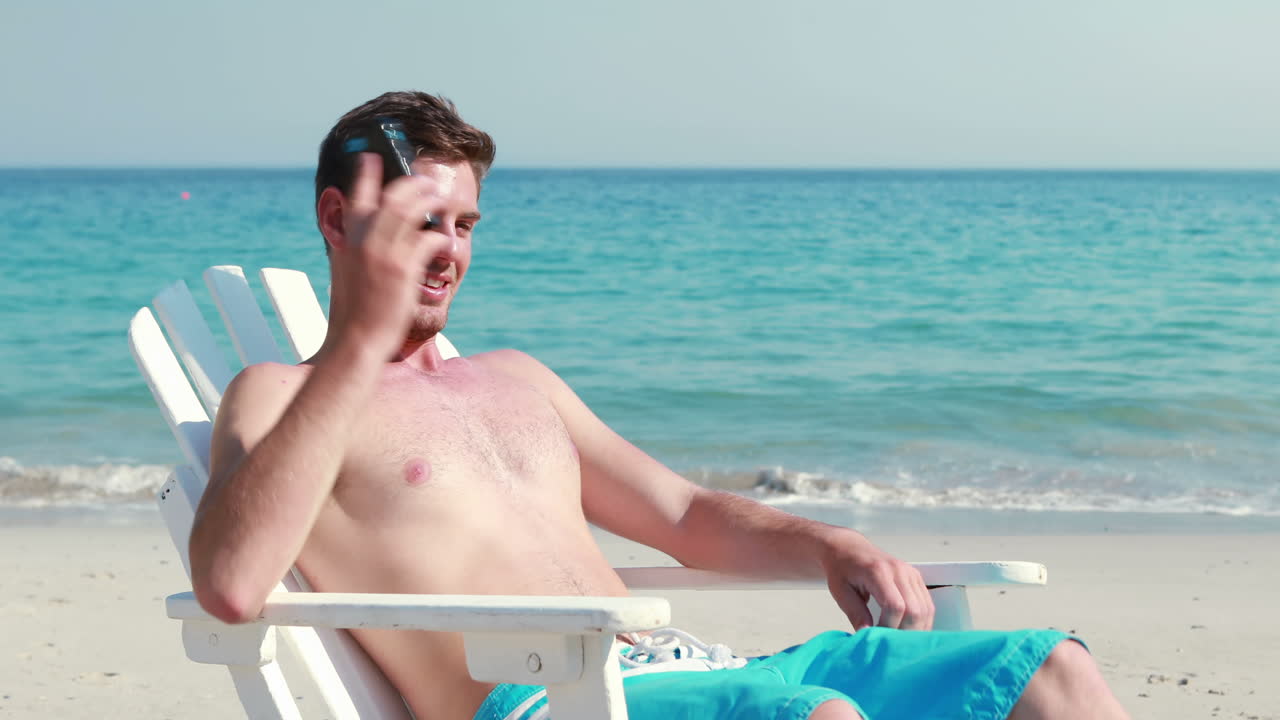 해변에서 전화를 하는 남자