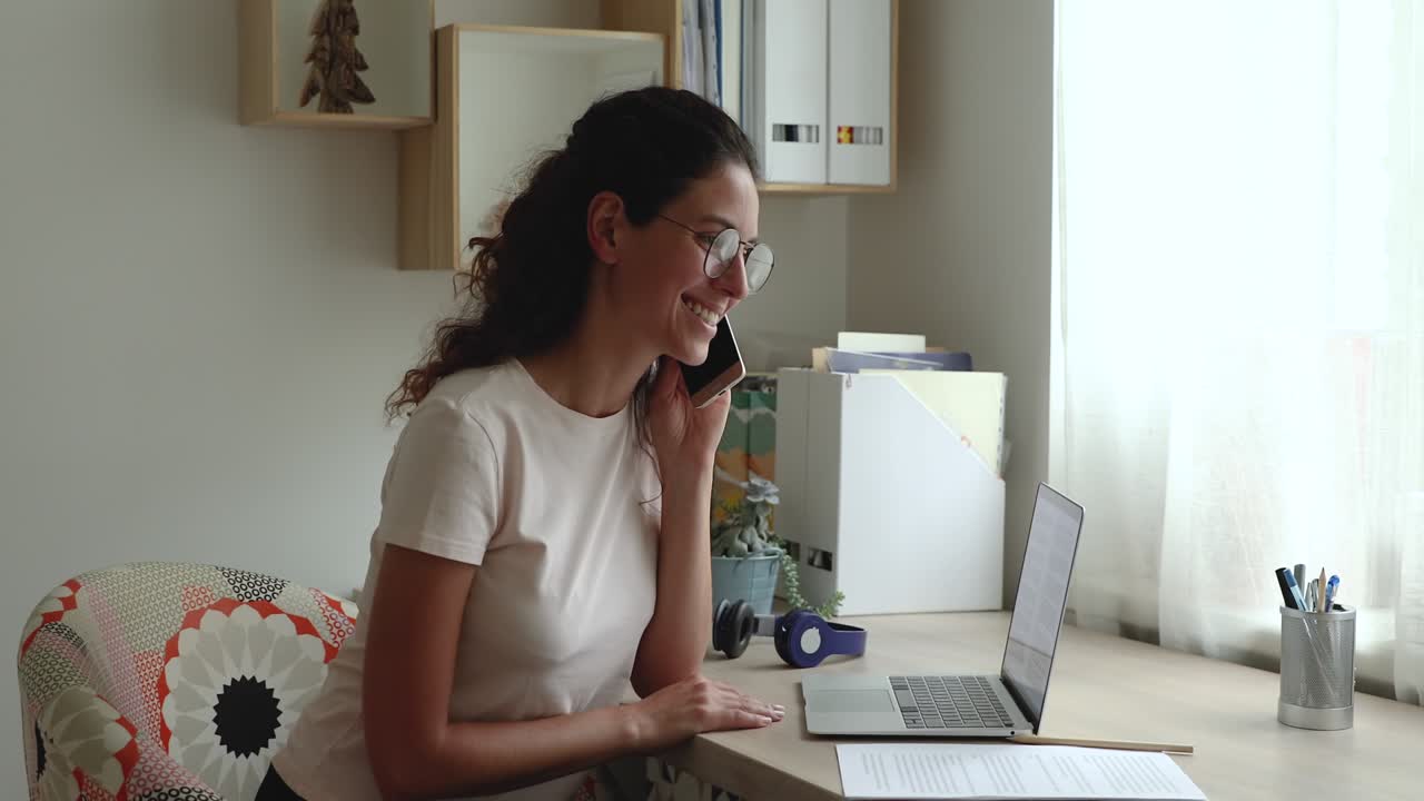 Business woman writes notes while talk on phone with colleague