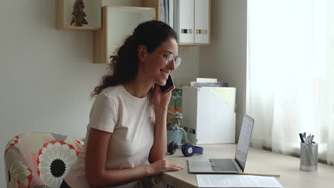 business woman writes notes while talk on phone with colleague
