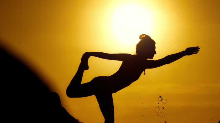 夕暮れのヨガをしている女性