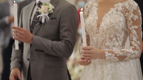 Los-Recién-Casados,-La-Novia-Y-El-Novio-Están-De-Pie-En-La-Iglesia,-Sosteniendo-Velas-En-Sus-Manos.-Ceremonia-De-Boda